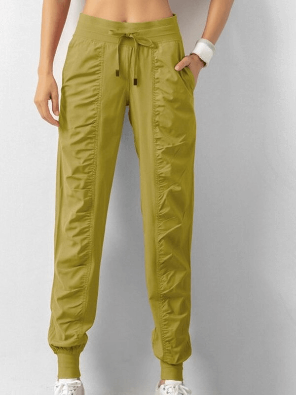 Women's sports joggers with cuffs and side pockets, featuring a drawstring waist, loose fit, and pleated front. Perfect for casual days.